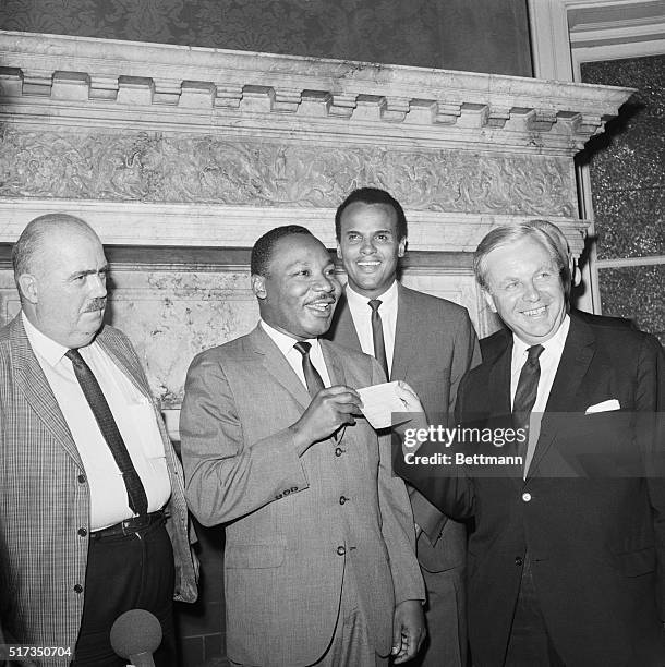 New York, NY: Civil rights leader Martin Luther King happily accepts a check for $100,000 from Tore Tallroth, Sweden's Consul General in New York....