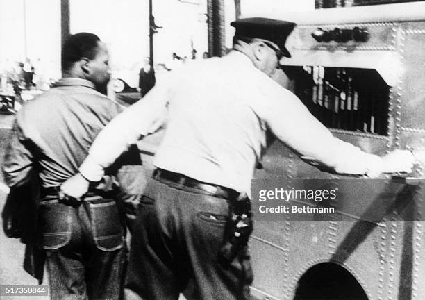 Birmingham, AL: A police officer grabs Southern integration leader Rev. Martin Luther King, Jr., by the seat of his trousers in jailing him for...