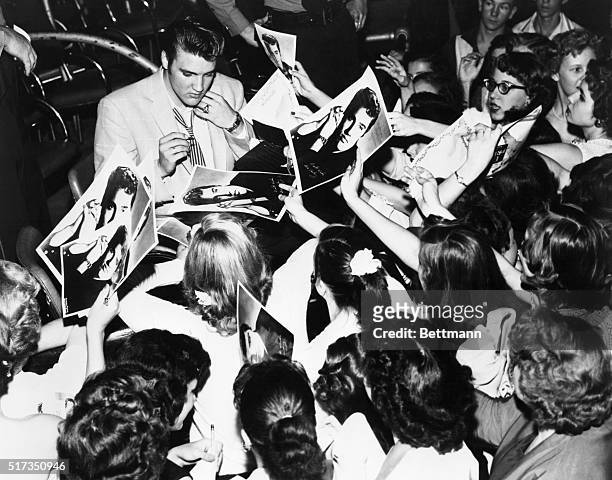 Elvis Presley, American singer surrounded by his enthusiastic teenage fans.