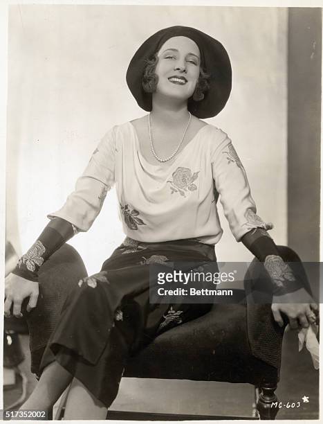 Norma Shearer, beautiful Metro-Goldwyn-Mayer star, poses in her new spring ensemble. A stunning afternoon gown in black and white with embroidered...
