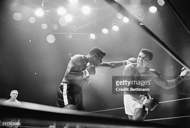Las Vegas, NV- A snarling Cassius Clay ducks under a long left jab by former champion Floyd Patterson, in the Las Vegas Convention Center during the...