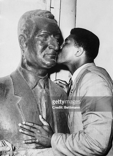 Cairo, U.A.R.- World heavyweight champion Cassius Clay kisses a bust of United Arab Republic President Gamal Abdel Nasser. Clay arrived here June 3rd...