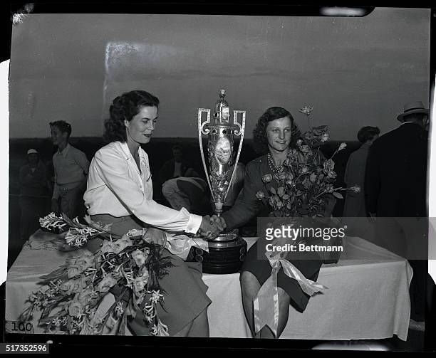 Mrs. Babe Didrikson Zaharias, of Denver, Colorado, is congratulated by Mrs. Clara Sherman, of Pasadena, California, after she took the cup for...