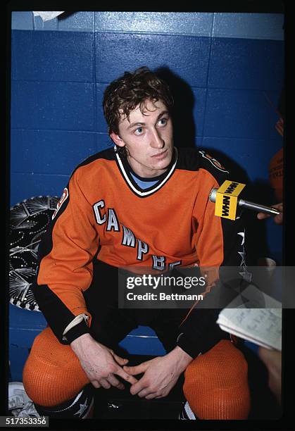 Wayne Gretzky, #99 of the Edmonton Oilers, is shown listening seriously to a reporter's question in the locker room after his fabulous four-goal...