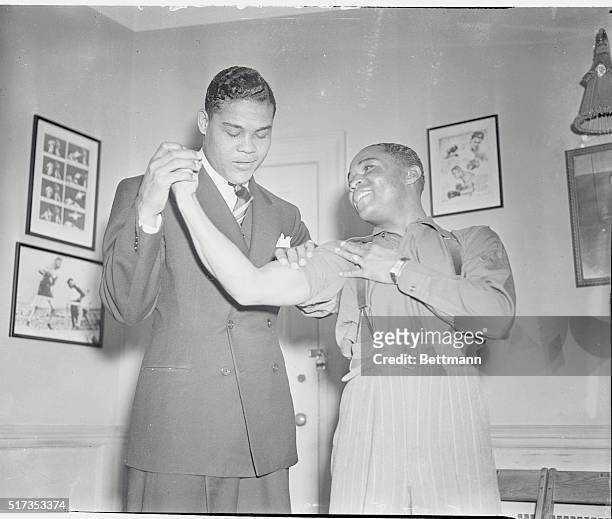 Joe Louis, heavyweight champion of the world, visited Henry Armstrong, holder of the lightweight and welterweight titles, during Henry's last workout...