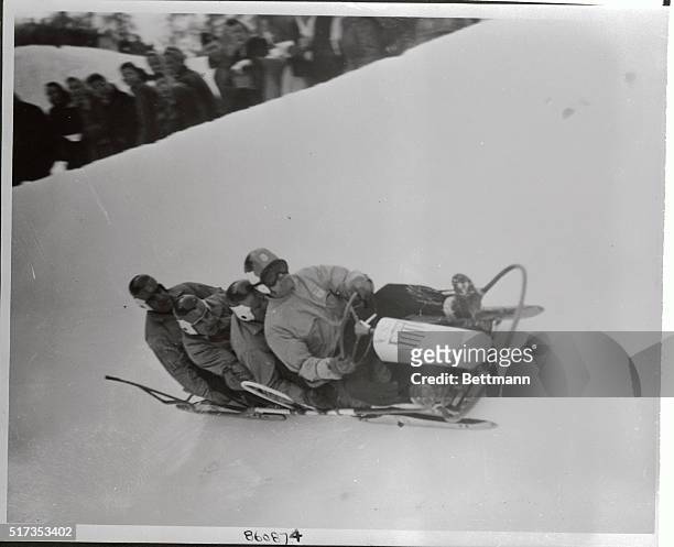 Members of the American bobsled team number two roar down the Olympic chute at St. Moritz to capture the event. Steersman Francis Tyler is backed up...