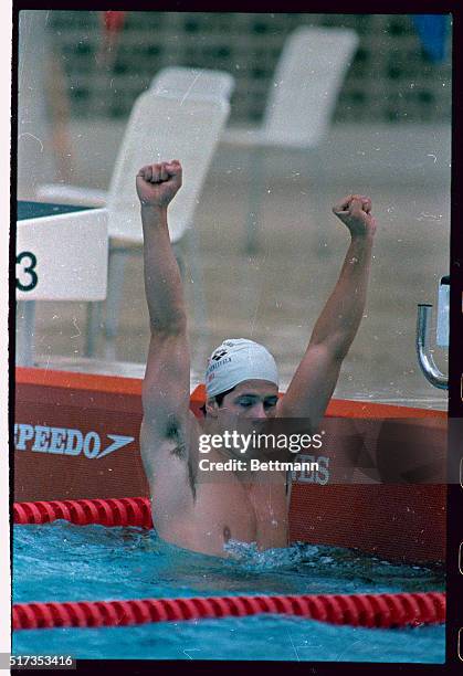 Rick Carey, the swimmer for the United States, raises his arms after setting a world record in the men's 100-meter backstroke in the Pan Am Games.