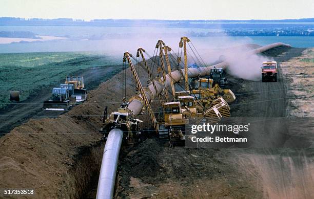 Cranes lift a large section of welded pipes, in the Moscovo Settlement of Bashkirsky Division, for the construction of Urengoi-Novopskov gas pipeline...
