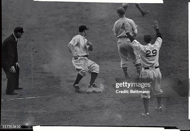 Lou Gehrig, star first baseman of the New York Yankees, planting one of his feet firmly on third base after Bill Dickey had singled in the seventh...