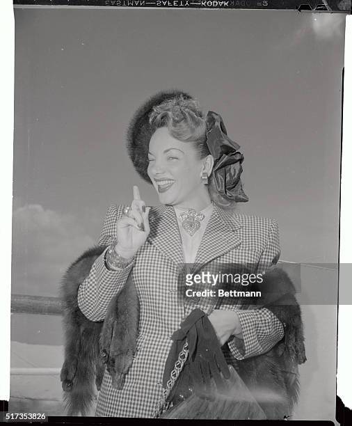 Carmen Miranda poses prettily on her return from Europe aboard the SS America. She was accompanied on her trip by her husband David Sebastian.