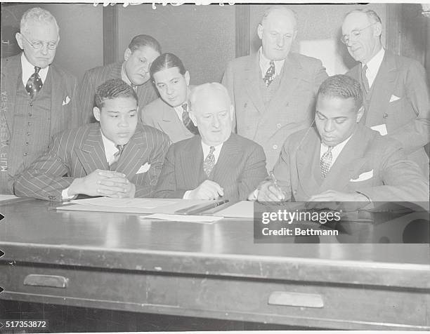 Louis and Lewis Make a Date. New York: Heavyweight champion Joe Louis and John Henry Lewis, recently deposed as light-heavyweight champion, are shown...
