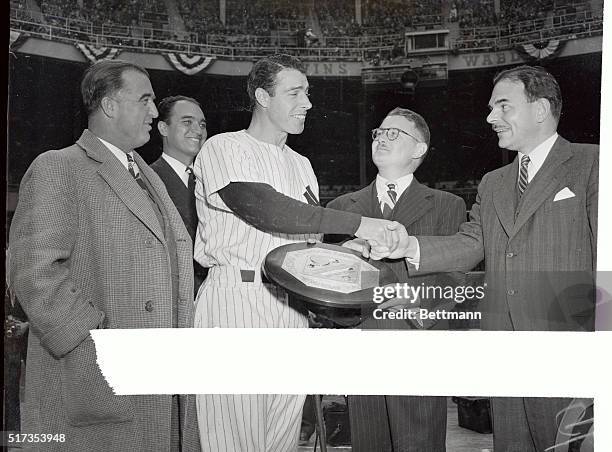 Governor Thomas E. Dewey congratulates Joe DiMaggio as the New York Yankees outfielder receives the Landis Memorial, emblematic of the Most Valuable...