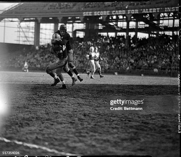 Sammy Baugh, passing star of the Washington Redskins professional football team, downs Eddie Rucinski, of the Brooklyn Dodgers , after the latter...