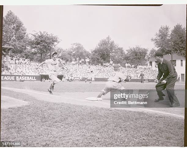 Williamsport, Pennsylvania: Little League game as a player runs to first base as an umpire waits for the throw to first base.