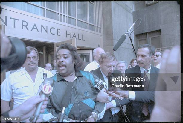 New York: The Rev. Al Sharpton lifts his manacled hands above his head as he leaves court here after he was arrested for allegedly stealing some...