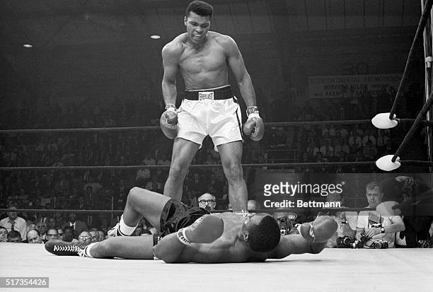 Heavyweight champion Muhammad Ali stands over Sonny Liston and taunts him to get up during their title fight. Ali knocked Liston out in one minute in...