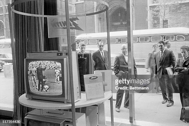 Businessmen stop outside the Zenith store window on Fifth Avenue to catch up on the televised New York Mets vs. Phillies baseball game. New York won...