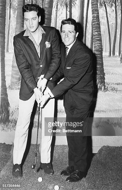 Masters champion Gary Player provides Elvis Presley with a few pointers on how to swing on the golf course. Player, whose takeoff of Elvis' antics...