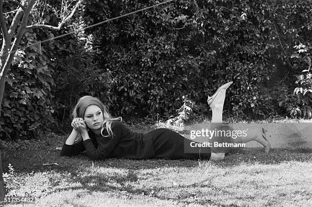 Brigitte Bardot stretches out on the grass between takes of Le Mepris. 1963.