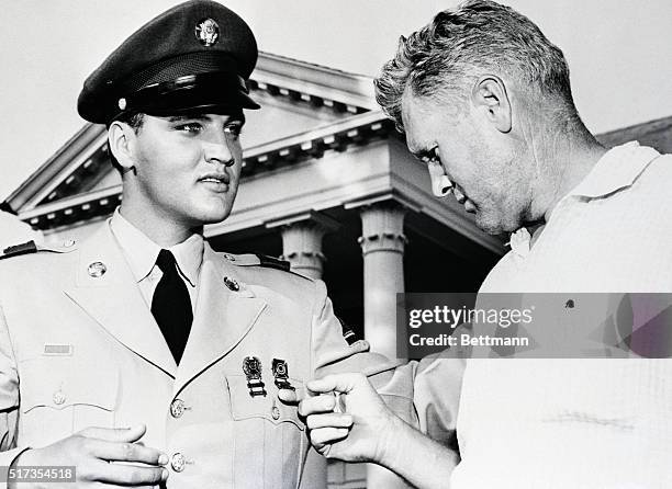 Memphis, Tennessee: Vernon Presley, Elvis Presley's father, looks like any other proud parent as he examines his sons medals, in front of the Presley...