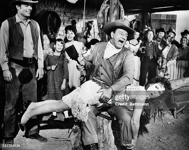 John Wayne, playing George McLintock, spanks Maureen O'Hara, playing his wife Katherine, in the Western-comedy McLintock!