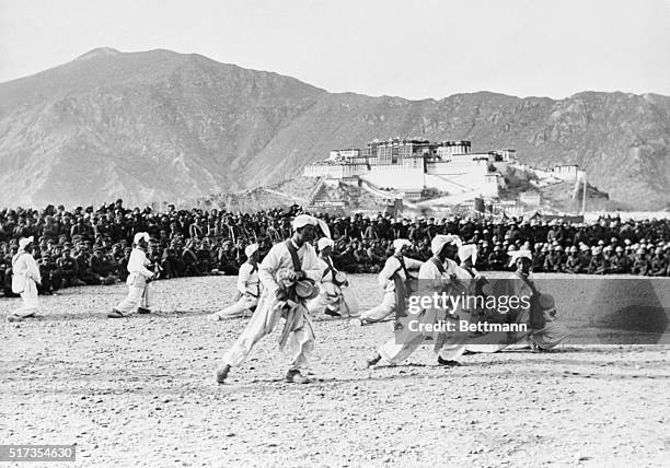 Tibetan dancers entertain Chinese Red Army troops in Lhasa in 1952, within view of the Dalai Lama's Potala Palace.
