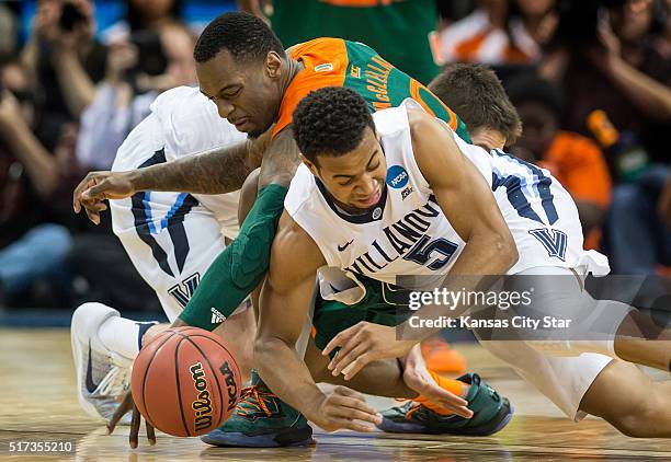 Miami's Sheldon McClellan and Villanova's Phil Booth scramble for a loose ball in the second half during a Sweet 16 matchup in the NCAA Tournament's...