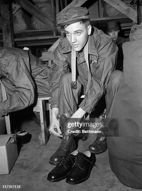 Fort Chaffee, AR: Elvis Presley, idol of a million teenagers, and the Army's property for the next two years, shows off the latest fashion in fatigue...