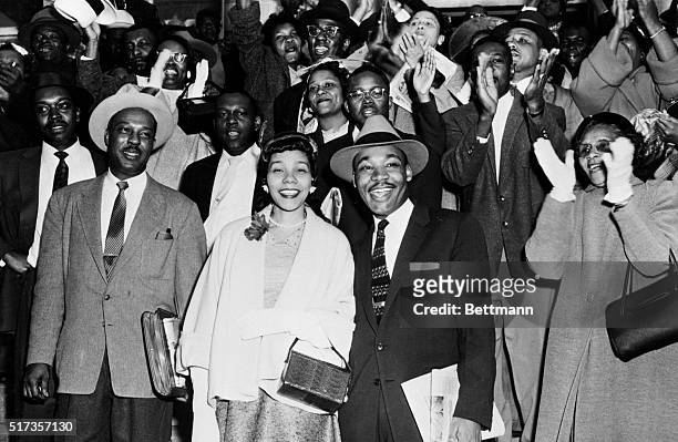 Reverend Martin Luther King Jr. And his wife Coretta Scott King smile broadly as they stand in front of a group of cheering followers after King's...