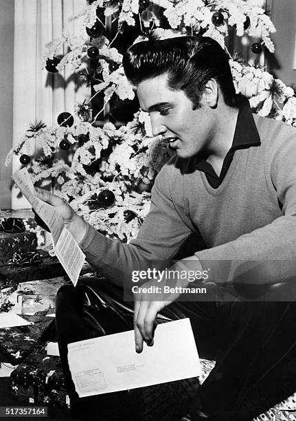 Memphis, TN: Rock 'n' roll crooner Elvis Presley reads an unexpected "greeting" -- a notice to report to military induction on January 20th. The idol...