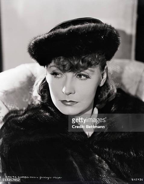 Head and shoulders portrait of Greta Garbo in dark fur hat and coat. Photograph. Movie Still. Metro Goldwyn Mayer