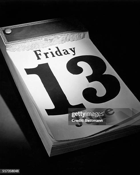 Closeup of a desk calendar with the date Friday, June 13th exposed. A dramatically lit object on a dark background. Undated photograph.