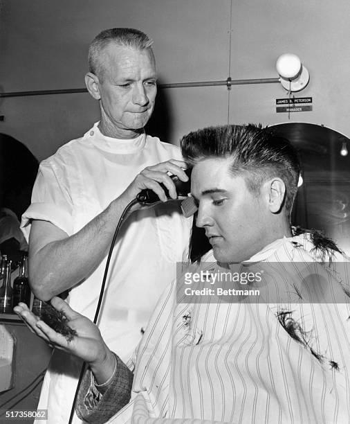 Elvis Presley receives a crew cut on his first full day as a member of the US Army.