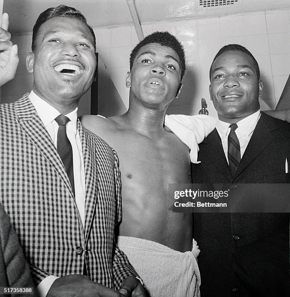 Muhammad Ali is joined in his dressing room by Sugar Ray Robinson and Jim Brown after defeating Doug Joes in a heavyweight contenders' fight.