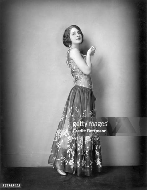 Norma Shearer, Metro-Goldwyn-Mayer featured player, seems the very essence of old Spain in this picture. The dress is of flame-red French veils,...