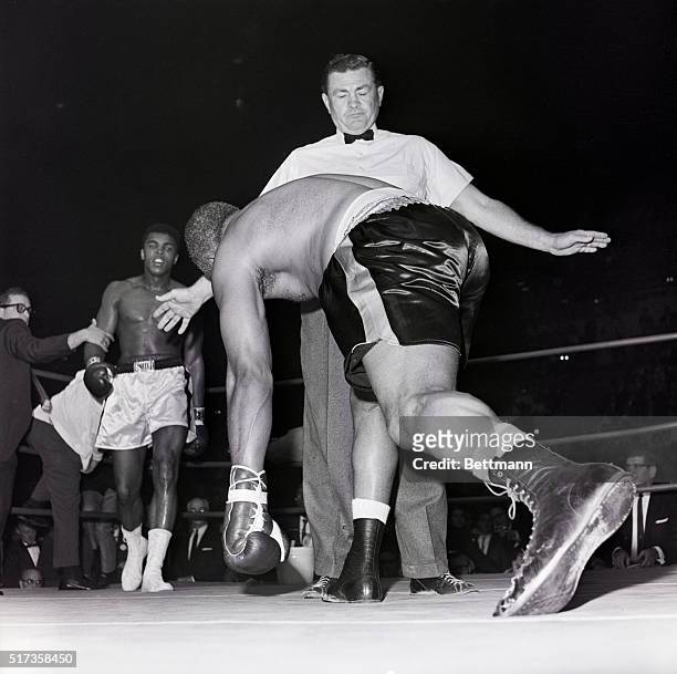 Los Angeles, CA-: Archie Moore tries to raise himself from the canvas after his third knockdown in the fourth round, but referee Tommy Hart calls him...