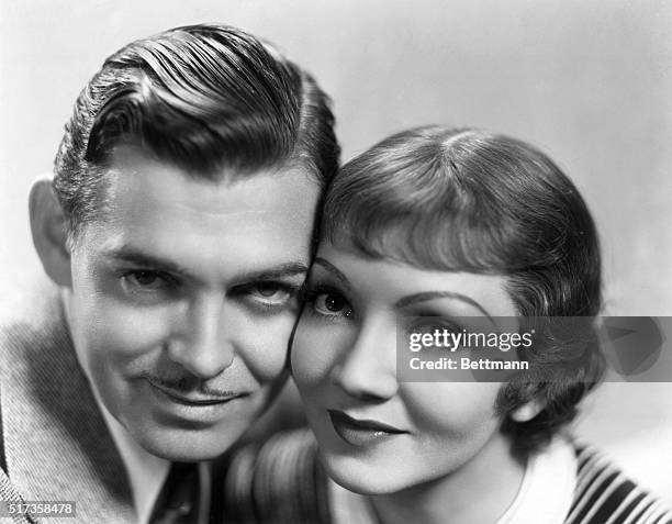 Clark Gable and Claudette Colbert pose for a publicity photo for Columbia's It Happened One Night, directed by Frank Capra. They pose cheek to cheek...