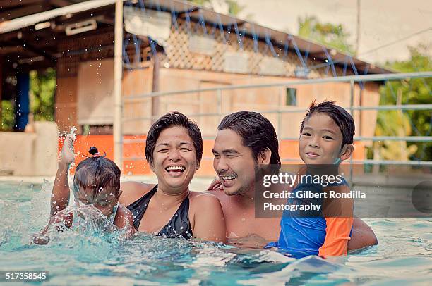 family of four in swimming pool - philippines family stock pictures, royalty-free photos & images