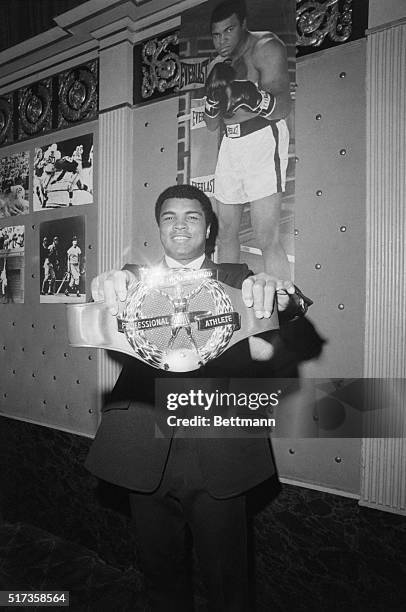 New York, NY- Heavyweight champion Muhammad Ali shows off the $15,000 diamond-studded belt he was awarded Jan 14th as "professional athlete of the...