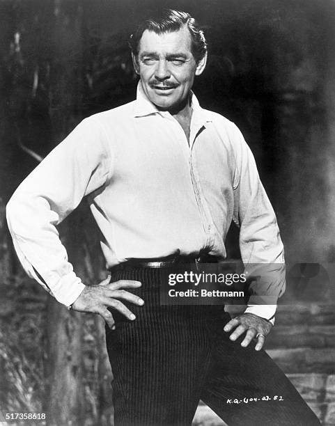 Portrait of actor Clark Gable. He is shown here in a 3/4 length shot, standing with his arms akimbo.