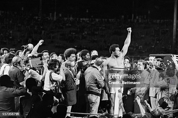 Kinshasa, Zaire- Heavyweight champion, George Foreman raises his arm to the crowd as he is weighted at the ring in Kinshasa. His challenger, Muhammad...