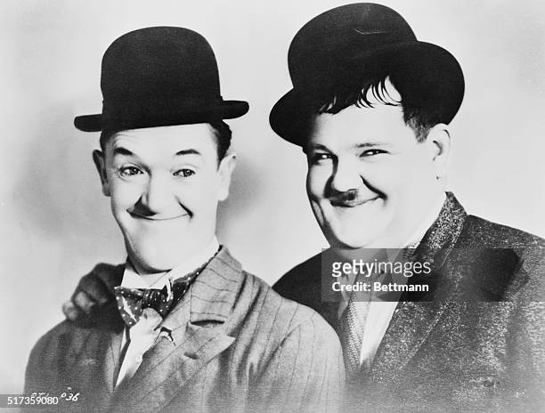 Head and shoulders portrait of Stan Laurel and Oliver Hardy wearing derby hats. Undated photograph.