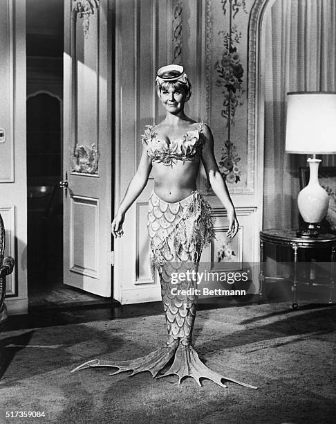 Jennifer Nelson presents a glamorous picture as she tries on the mermaid outfit she will wear while swimming under her father's glass-bottom boat off...
