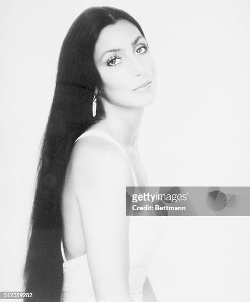 Glamorous portrait of singer Cher Bono. She is shown waist-up, with long hair.