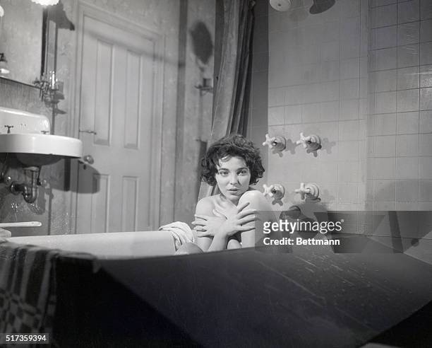 Surprised while taking a bath, starlet Joan Collins shows the proper emotion, during a scene in the new Warner Brothers film, "The Wayward Bus." The...