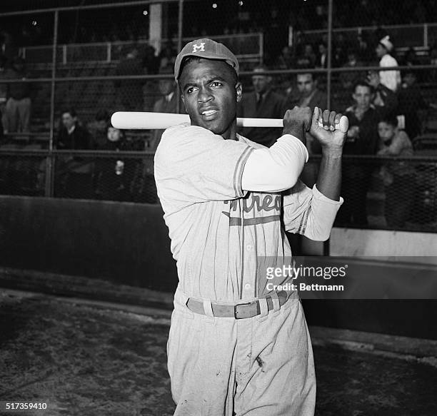 New York, NY-Jackie Robinson, first Black man to be signed up by a Major League baseball team, is shown in post-swing position in front of the...
