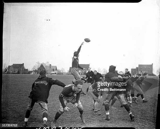 Sammy Baugh, champion passer of the Eastern Professional football League, is pictured making a difficult pass through his teammates as they try to...