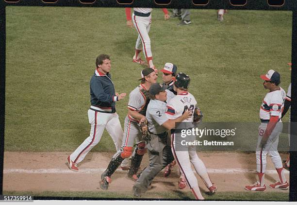 Chicago, Illinois: After being hit on the knee by a ball pitched by Orioles' Mike Flanagan, White Sox outfielder Ron Kittle is restrained by plate...