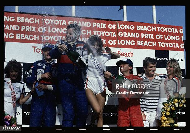Winners of the 1983 Toyota Grand Prix in Long Beach, CA, spray champagne from the winners stand. They are : second place driver, Nikki Lauda; winner...