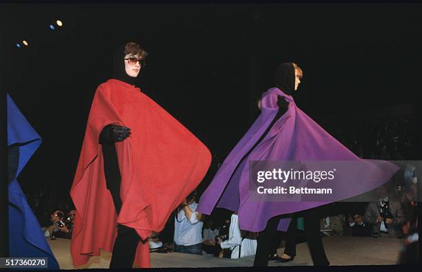 Fashion model walks down the runway for Ralph Lauren's Casual and Winter Wear show. She is wearing a bright yellow serape, with black pants, black...